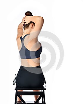 Woman on chair making body twist sideway back view photo