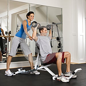 Woman spotting man at gym photo