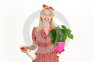 Woman with spray bottle spraying houseplants. Watering concept. Irrigation. Girl take care of flowers.