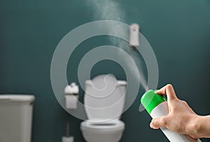 Woman spraying air freshener