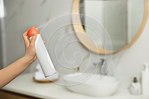 Woman spraying air freshener in bathroom