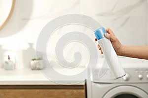 Woman spraying air freshener in bathroom