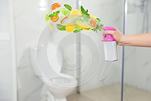 Woman spraying air freshener in bathroom. Citrusy and minty aroma