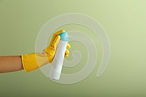 Woman spraying air freshener on color background