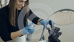 Woman spraying cleaning liquid on her shoes. Proper shoe care