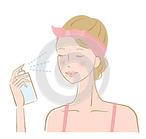 Woman spraying facial mist on her face