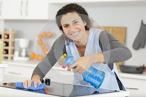 woman spraying houshold cleaner on kitchen counters