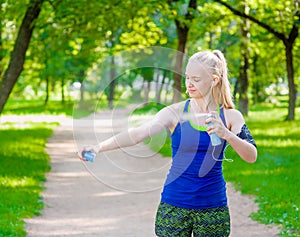 Woman spraying insect repellents on skin before run