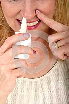 Woman Spraying Nasal Spray in Nose 2 photo