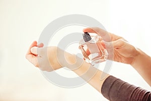 Woman spraying perfume on her wrist