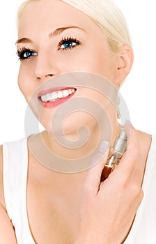 Woman spraying perfume on neck