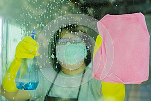 Woman spraying and wiping glass