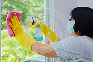 Woman spraying and wiping glass photo