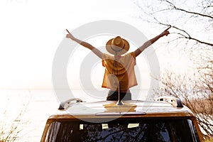 Woman Spread Arms Widely at Car Sunroof Back View