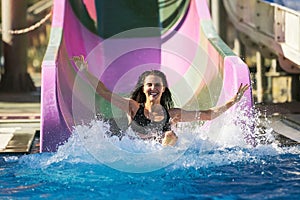 Woman spreading hands having fun on the water slide