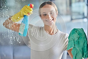 Woman, spring cleaning spray and bottle for windows in house with cloth for dust, bacteria and dirt in room, apartment