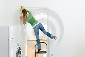 Woman at the spring cleaning working dangerously