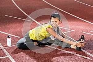 Woman sprinter doing warm up exercise before sprint