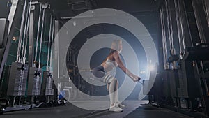 A woman is squatting with a rope in a gym during an event
