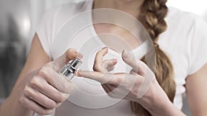 Woman squeezes a drop of cream from the bottle dispenser to the finger tip, face and body care, cosmetics for body