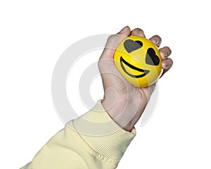 Woman squeezing antistress ball with funny face on white background, closeup