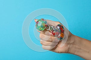 Woman squeezing colorful slime on blue background. Antistress toy