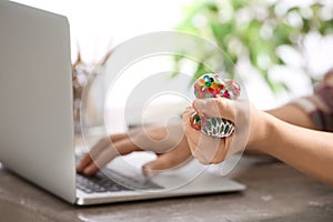 Woman squeezing colorful slime in office. Antistress toy