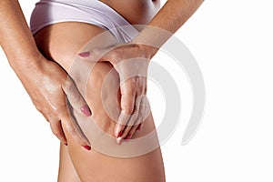Woman squeezing her thigh to show cellulite