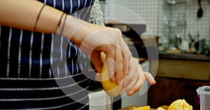 Woman squeezing lemon in bowl at cafe kitchen 4k