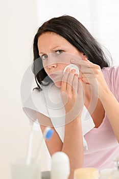 Woman squeezing pimple cleaning acne skin photo