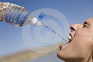 Woman squirting water into mouth photo