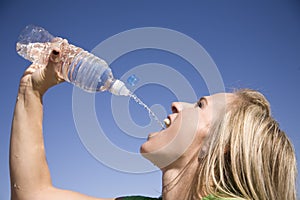Woman squirts water into mouth