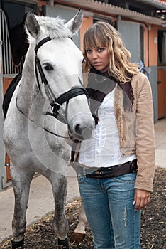 Woman in a stable before riding her horse