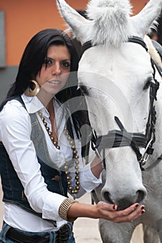 Woman in a stable before riding her horse