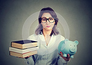 Woman with stack of books and piggy bank full of debt rethinking career path