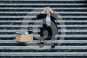 woman on stairs, reflecting on her situation after dismissal and workloss,