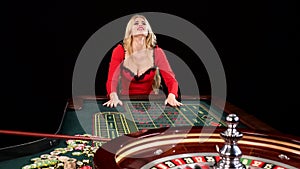 Woman stakes piles of chips playing roulette at the casino. Black