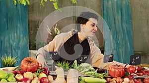 Woman stand holder wearing apron running farmers market counter