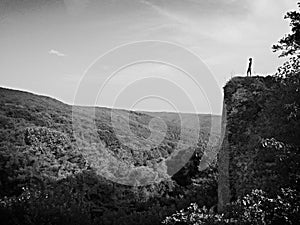 A Woman stand on a rock black and white