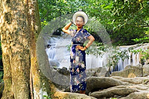 Woman stand at tree on waterfall  at Erawan Waterfall