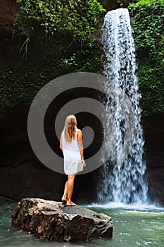 Woman stand under waterfall