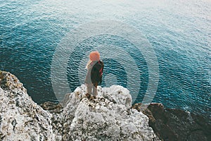 Woman standing above cold sea on cliff alone Travel Lifestyle concept outdoor