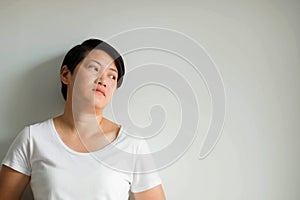 A woman standing against the wall with loneliness, feeling depressed and dispirited on white background