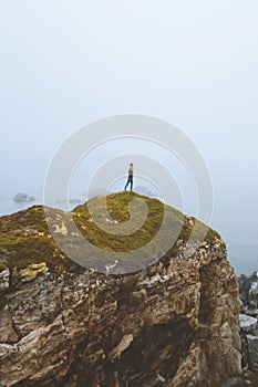 Woman standing alone on rocky cliff travel vacation adventure lifestyle outdoor