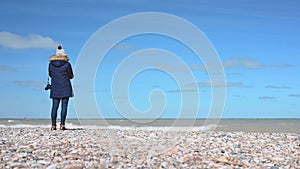 Woman standing along Lake Michigan shoreline in winter coat