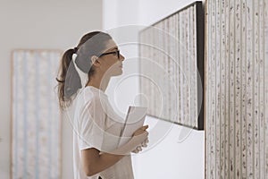 Woman standing in the art gallery and looking at the paintings