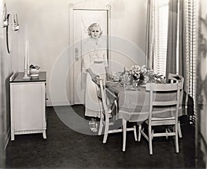 Woman standing by beautifully set dining room table