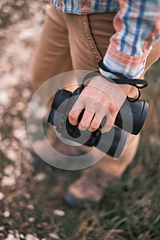 Woman is standing with binoculars in her hand. Selective focus on binoculars.