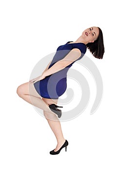 Woman standing in a blue tight dress bending backwards