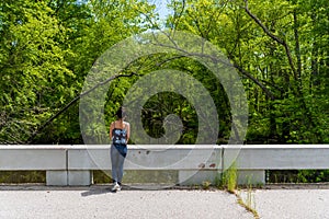 Woman standing on bridge near Swampy river off highway in Virginia